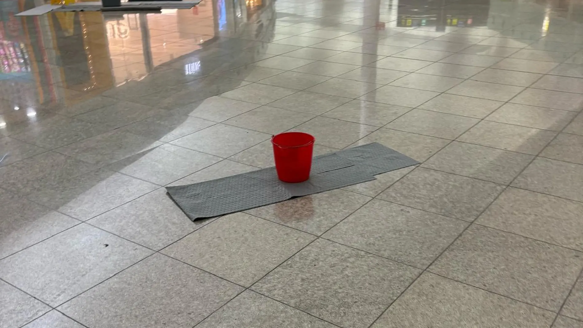 Un cubo tratar de recoger el agua provocada por las goteras en el aeropuerto de El Prat