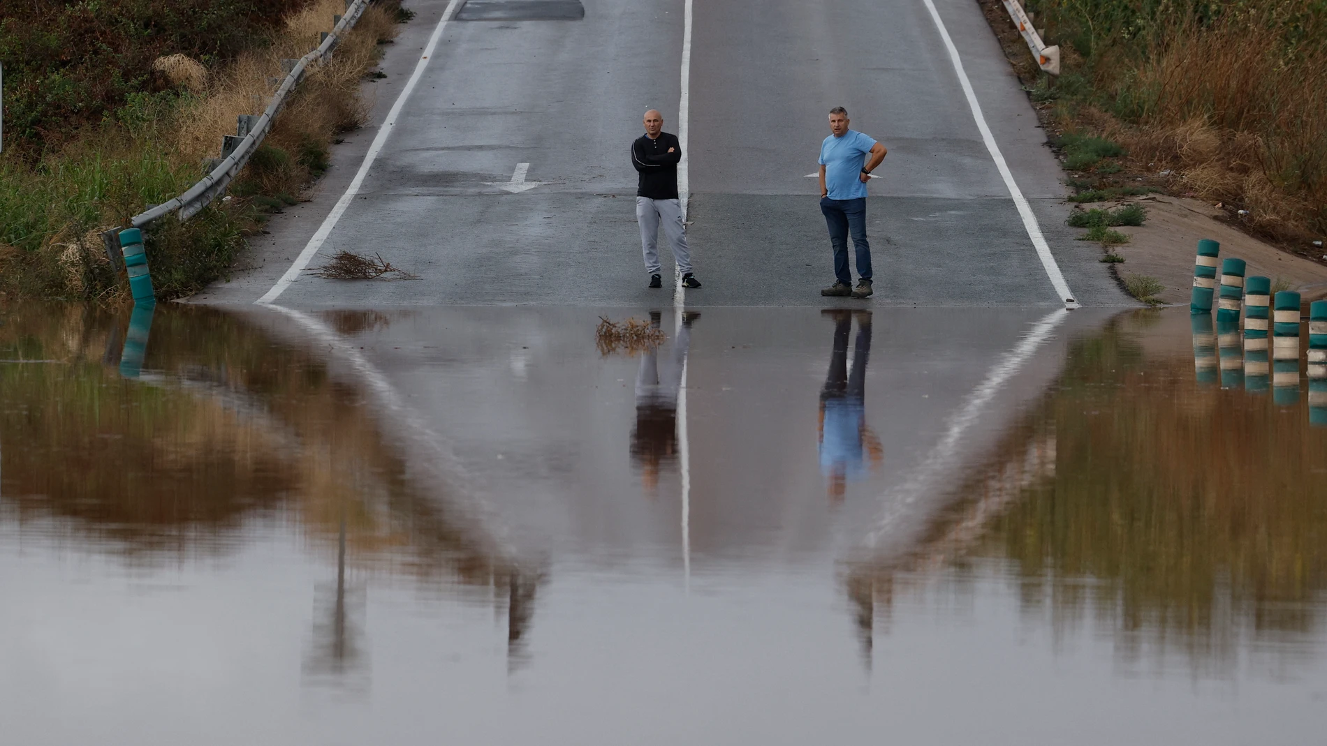 SAGUNTO (VALÈNCIA), 01/07/2024.-Dos personas obsevan un área anegada en Sagunto este lunes. La Comunitat Valenciana registra en las primeras horas de este lunes lluvias y tormentas de intensidad muy fuerte, localmente torrencial en Castellón y en la mitad norte de la provincia de Valencia, que han sido de 59 litros por metro cuadrado (l/m2) en Xodos (Castellón) y de 56,4 litros en Utiel (Valencia). Aemet había alertado de la situación meteorológica muy adversa desde la madrugada de este lunes...