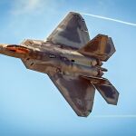 El característico perfil de un F-22 con su cabina "dorada".