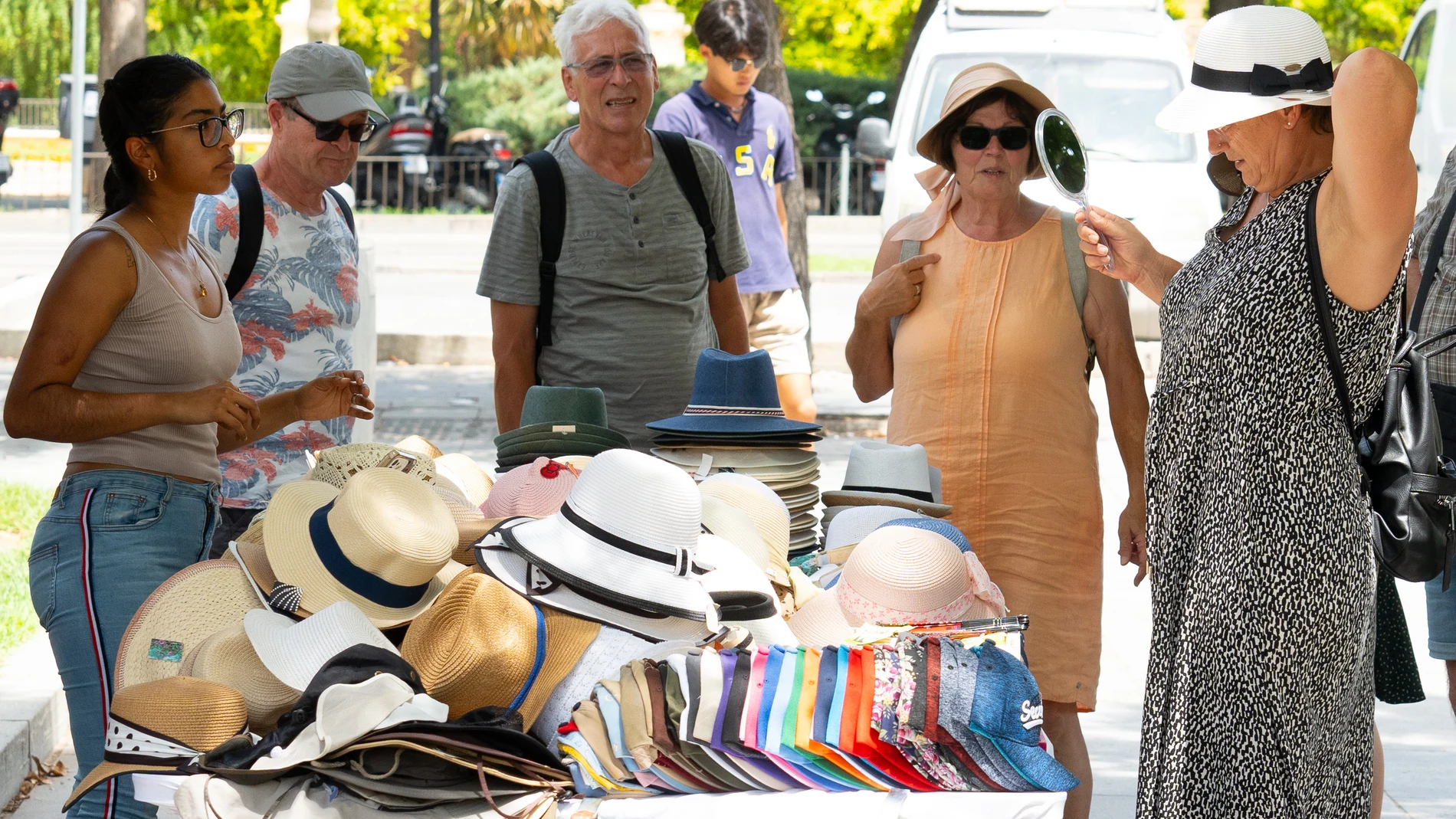 Unos turistas compran gorros para protegerse del sol, a 19 de julio de 2024, en Sevilla, Andalucía (España). La primera ola de calor del verano pone en alerta a Sevilla por altas temperaturas, tanto en la campiña como en la sierra norte.19 JULIO 2024Francisco J. Olmo / Europa Press19/07/2024