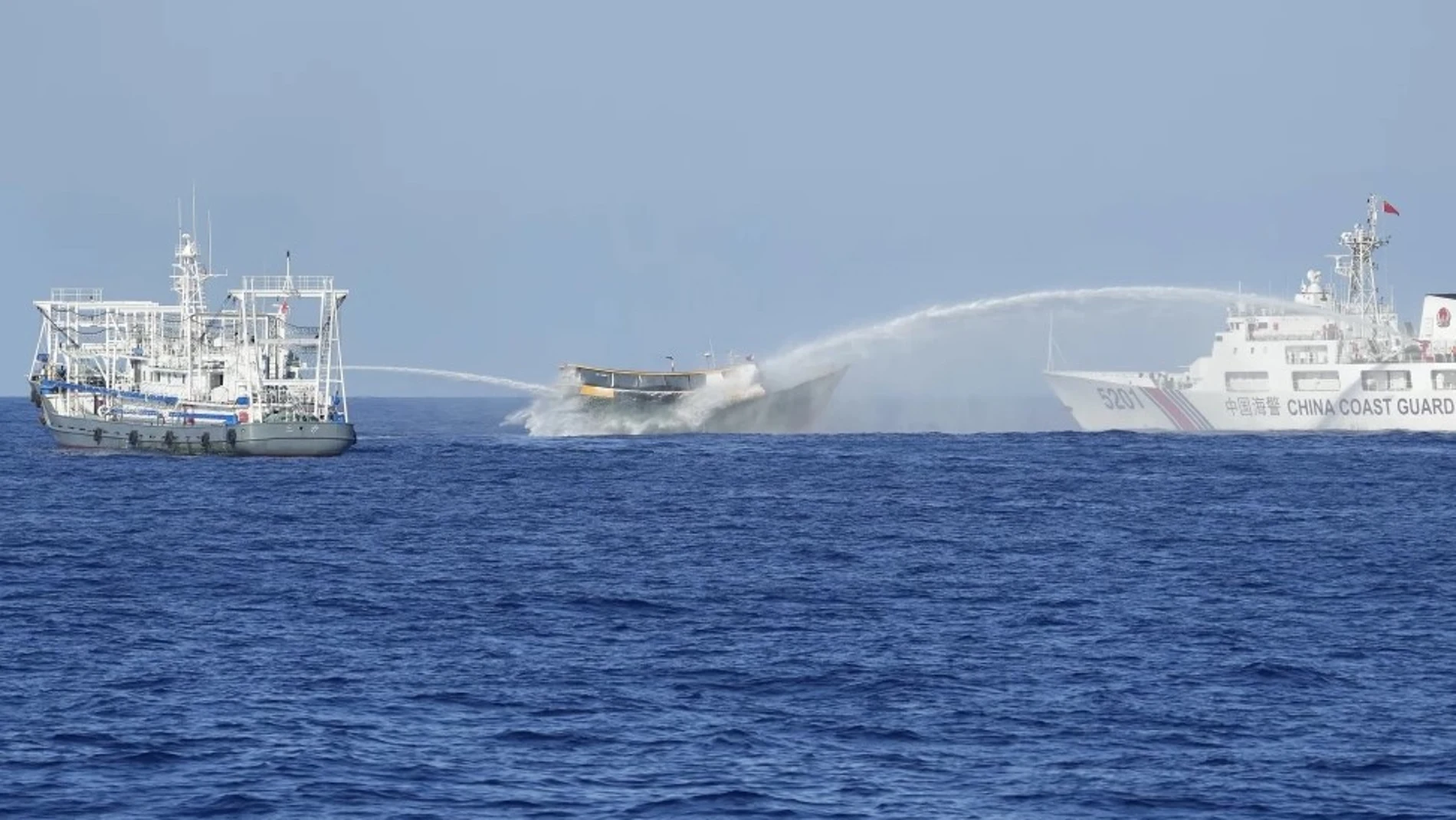 Un buque filipino, en el centro, es alcanzado por cañones de agua de dos barcos guardacostas chinos cuando intentaba llegar al disputado atolón Second Thomas, en el Mar de China Meridional