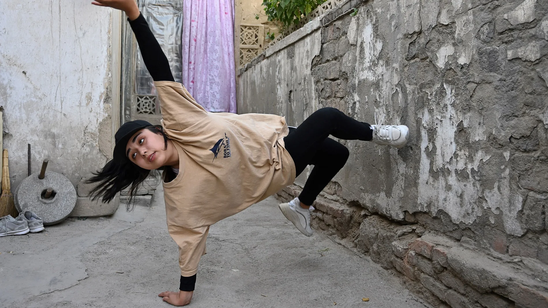 In this photo taken on June 12, 2021, Manizha Talash, the only female member of a group of breakdancers comprised of mostly Hazara boys, practices a move in Kabul. The Taliban outlawed dozens of seemingly innocuous activities and pastimes in Afghanistan during their 1996-2001 rule -- including kite flying, TV soap operas, pigeon racing, fancy haircuts, and even playing music. These have made a comeback in the years since, but fears are growing they will be banned again if the hardline Islamists return to power. (Photo by ADEK BERRY / AFP) / TO GO WITH'AFGHANISTAN-CONFLICT-TALIBAN-LEISURE',FOCUS BY JAY DESHMUKH AND AFP'S AFGHANISTAN TEAM - TO GO WITH'AFGHANISTAN-CONFLICT-TALIBAN-LEISURE',FOCUS by Jay DESHMUKH and AFP's Afghanistan team