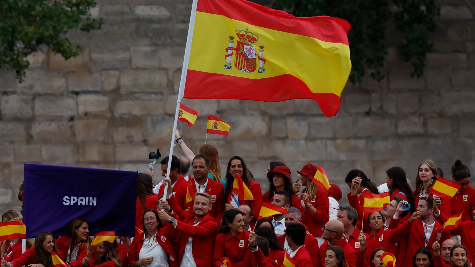 PARÍS (FRANCIA), 26/07/2024.- Los abanderados de España la regatista Támara Echegoyen (c-i) y el piragüista Marcus Cooper (c-d) junto al resto de la delegación durante el desfile por el río Sena, en el marco de la ceremonia de inauguración de los Juegos Olímpicos de París 2024, este viernes en la capital francesa. EFE/Julio Muñoz