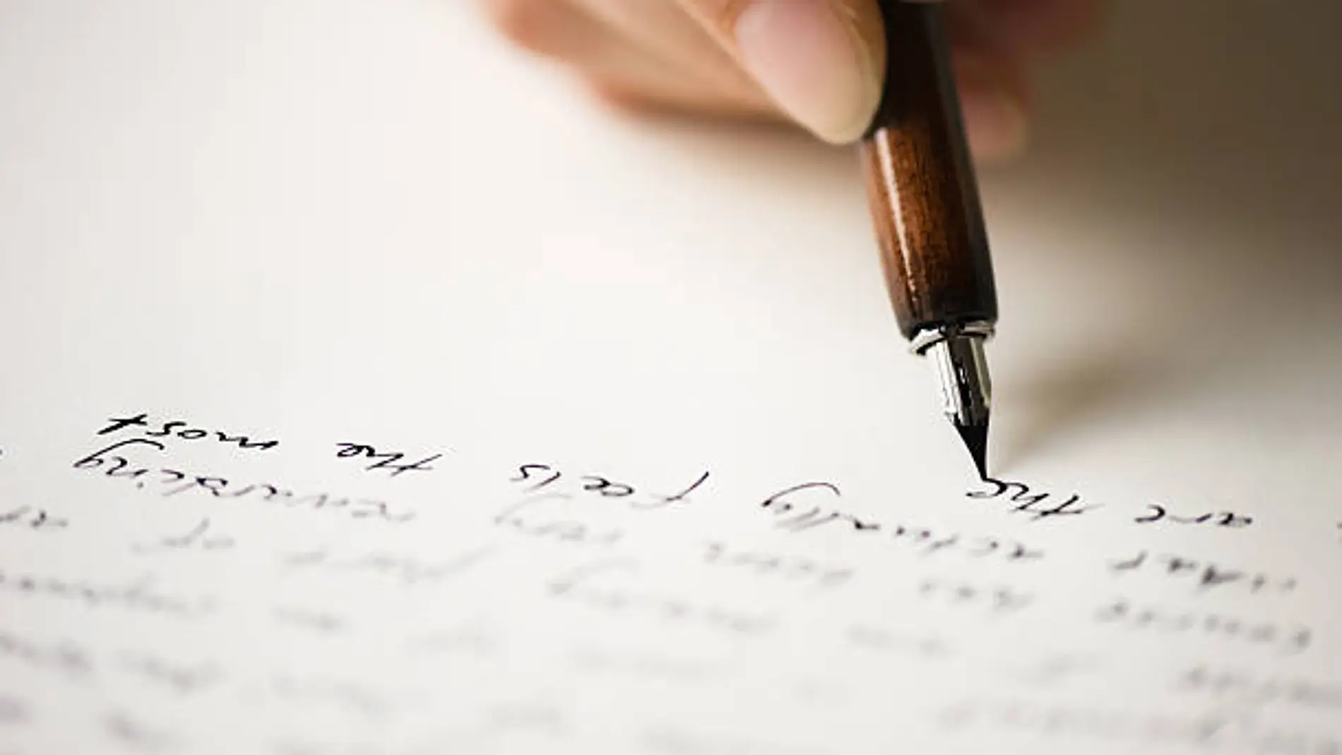 Una persona escribiendo sobre una hoja