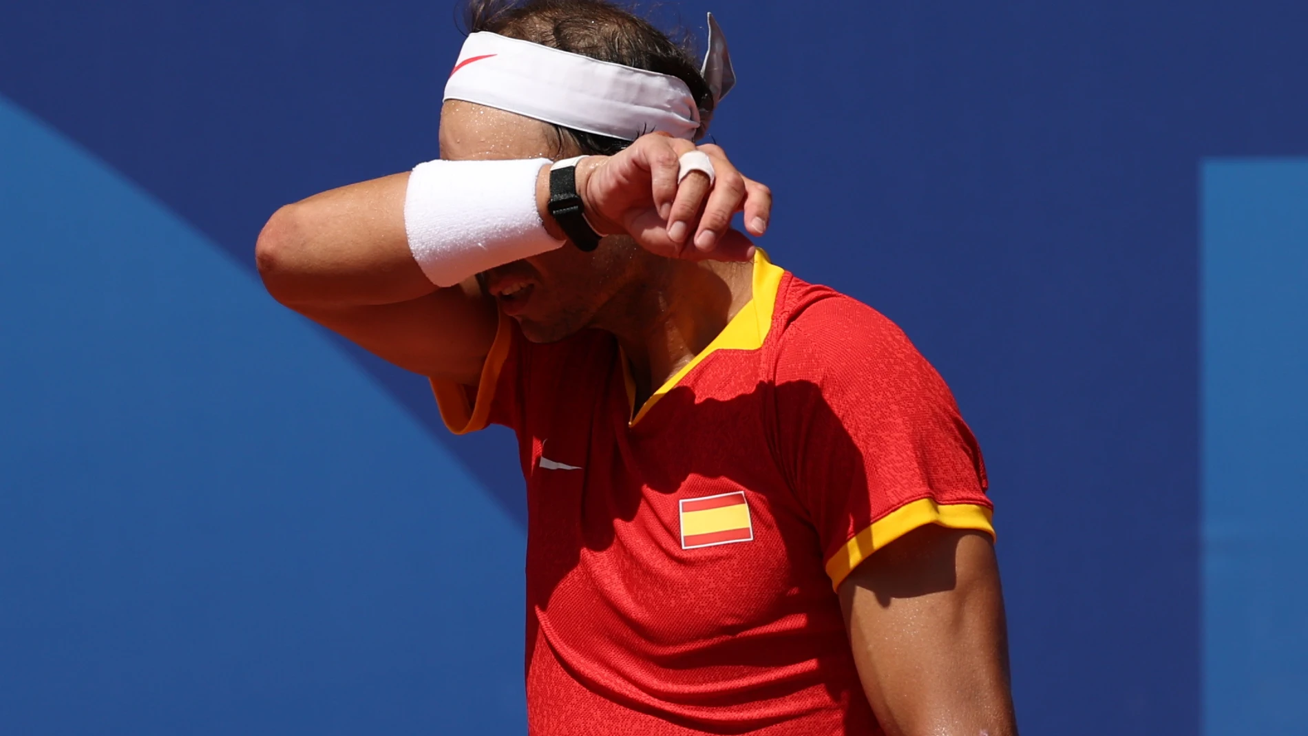 PARÍS, 29/07/2024.- El tenista español Rafa Nadal se seca el sudor ante el serbio Novak Djokovic durante el partido celebrado en el marco de los Juegos Olímpicos de París, este lunes. EFE/ Juanjo Martín