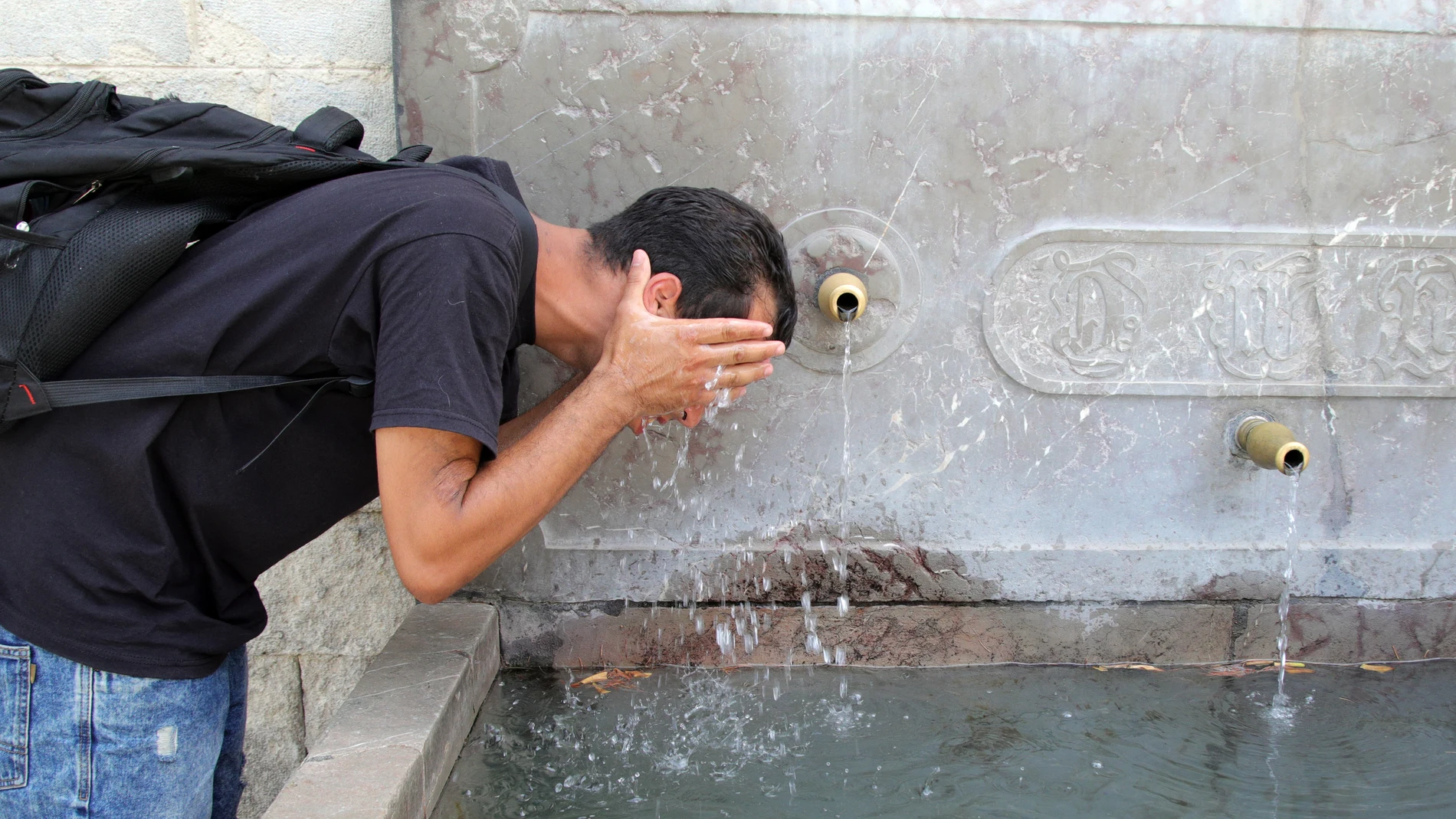 GRAFAND2787. GRANADA, 01/08/2024.- Una joven se refresca hoy en Granada en el tercero y último día de la tercera ola de calor de este verano donde las temperaturas descenderán de forma leve y, aunque dejan atrás los valores sofocantes de los días anteriores, se registrarán temperaturas elevadas que superarán los 40 ºC en puntos del sur y nordeste peninsular.EFE/ Pepe Torres