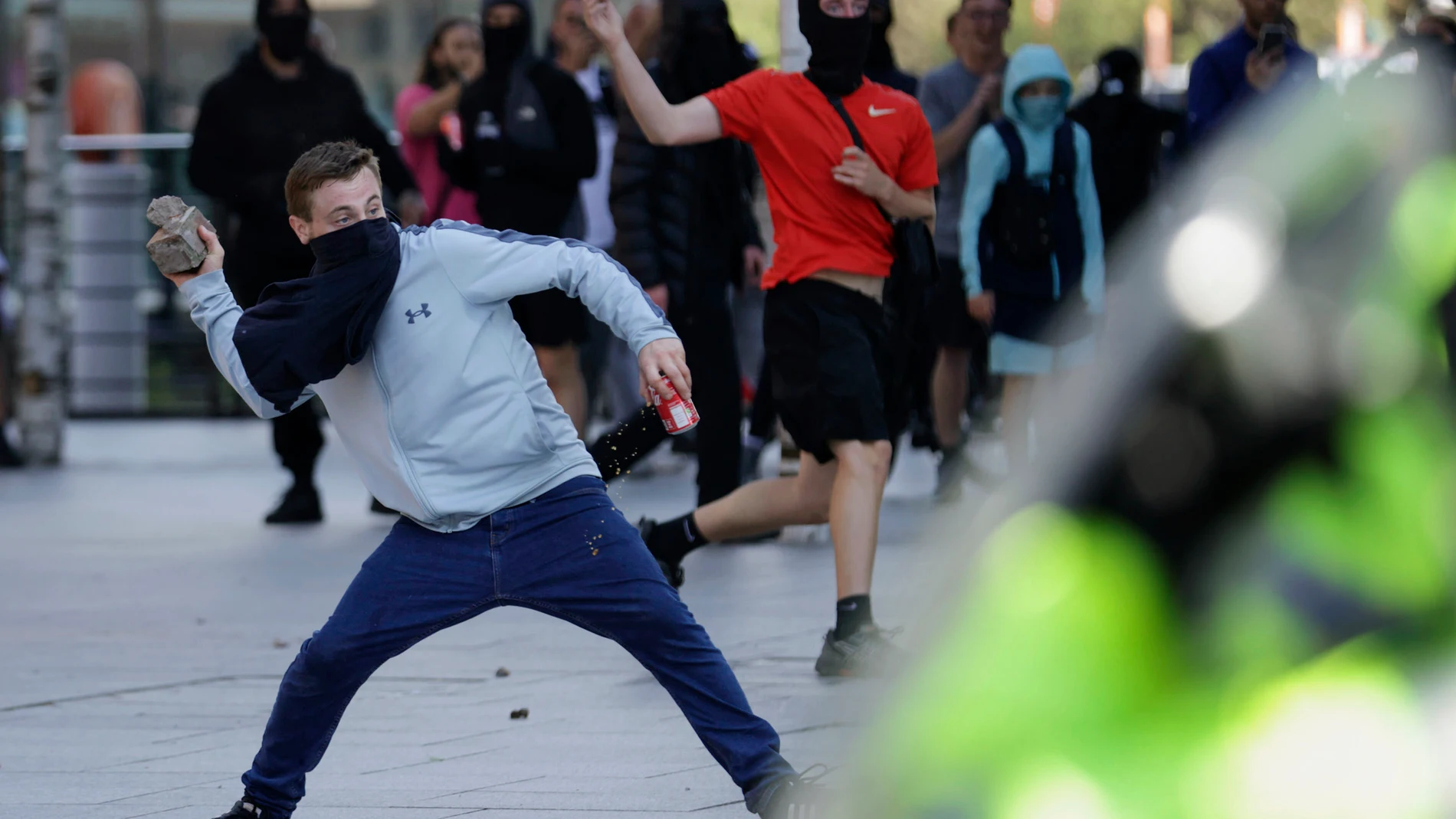 A demonstrator throws a brick during a protest in Liverpool, England, on Saturday, Aug. 3, 2024, following Monday's stabbing attacks in Southport, in which three young children were killed. (James Speakman/PA via AP)
