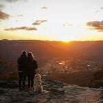 Personas abrazadas en la cima de una montaña