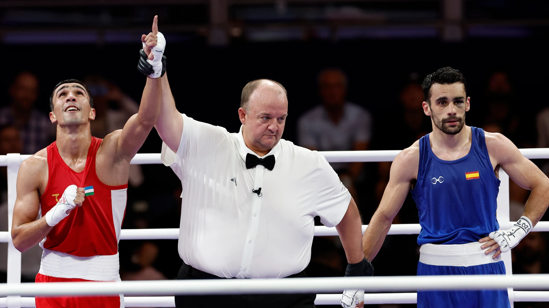 SEINE-SAINT DENIS, 03/08/2024.- El boxedor uzbeco Abdumalik Khalokov (rojo) (i) celebra su victoria ante el español José Quiles Brotons (azul) tras el combate de boxeo masculino de cuartos de final, categoría 57kg, de los Juegos Olímpicos de París 2024, en North Paris Arena de Seine-Saint Denis. EFE/ Miguel Toña