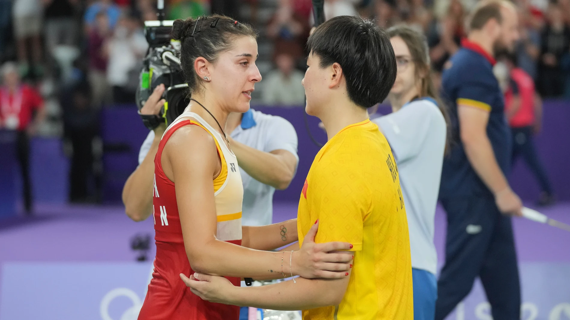 Spain's Carolina Marin, left, suffers an injury as she plays against China's He Bingjiao during their women's singles badminton semifinal match at the 2024 Summer Olympics, Sunday, Aug. 4, 2024, in Paris, France. (AP Photo/Dita Alangkara)