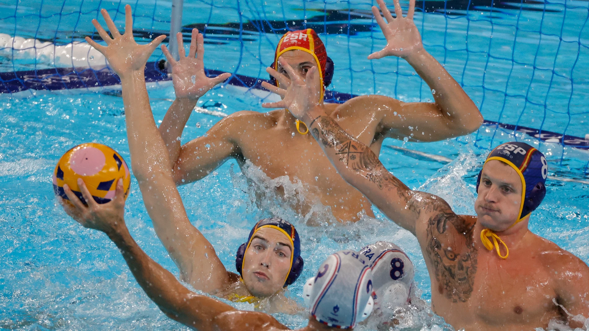 NANTERRE, 05/08/2024.- El jugador francés Ugo Crousillat (c) lanza ante la defensa española durante el partido de la ronda preliminar de waterpolo de los Juegos Olímpicos París 2024, que Francia y España disputan este lunes en Nanterre, Francia. EFE/ Lavandeira Jr