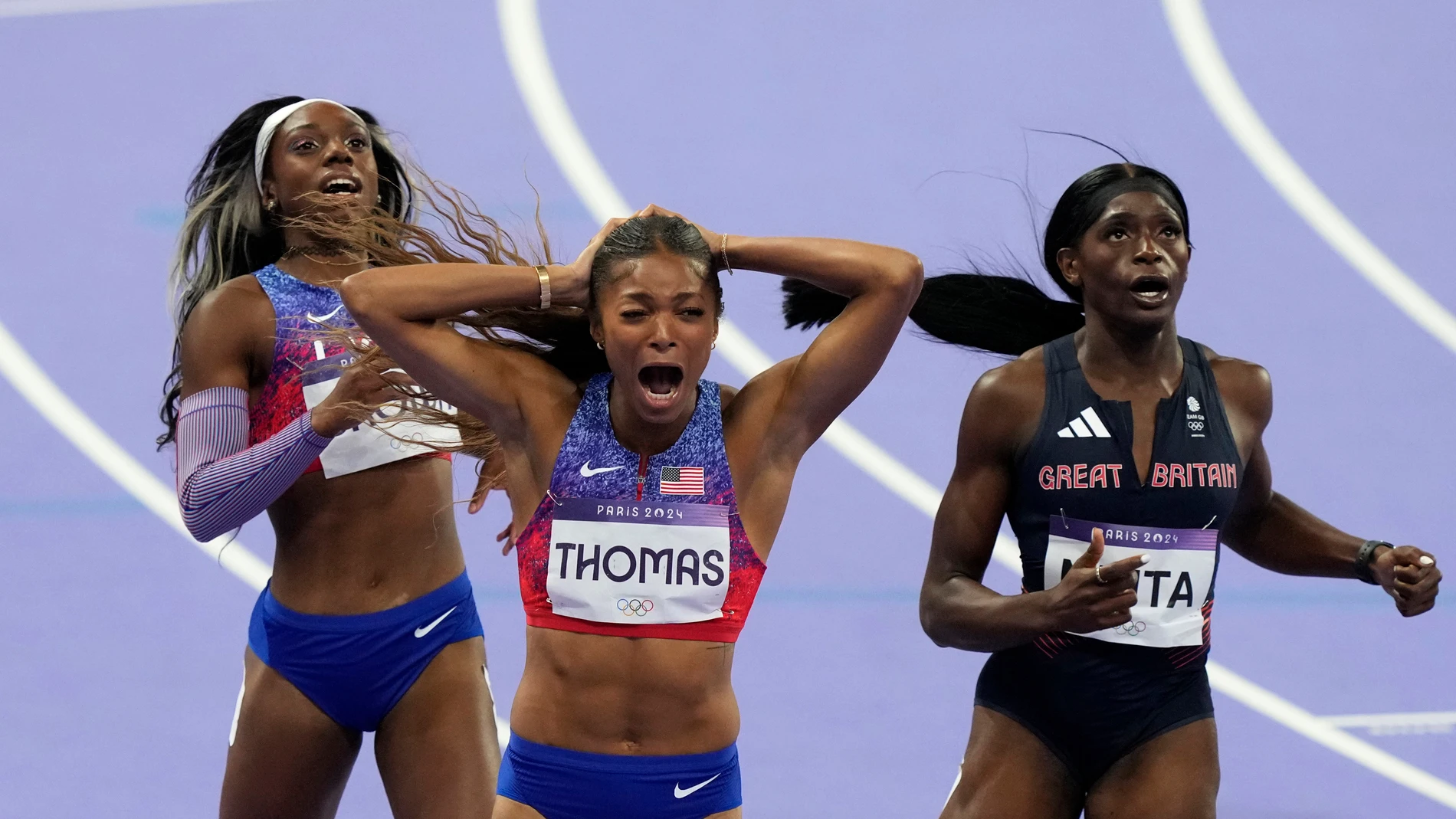 Gold medalist Gabrielle Thomas, and bronze medalist Brittany Brown, both of the United States, and fifth placed Daryll Neita, of Britain, react after crossing the finish line in the women's 200 meters final at the 2024 Summer Olympics, Tuesday, Aug. 6, 2024, in Saint-Denis, France. (AP Photo/Martin Meissner)