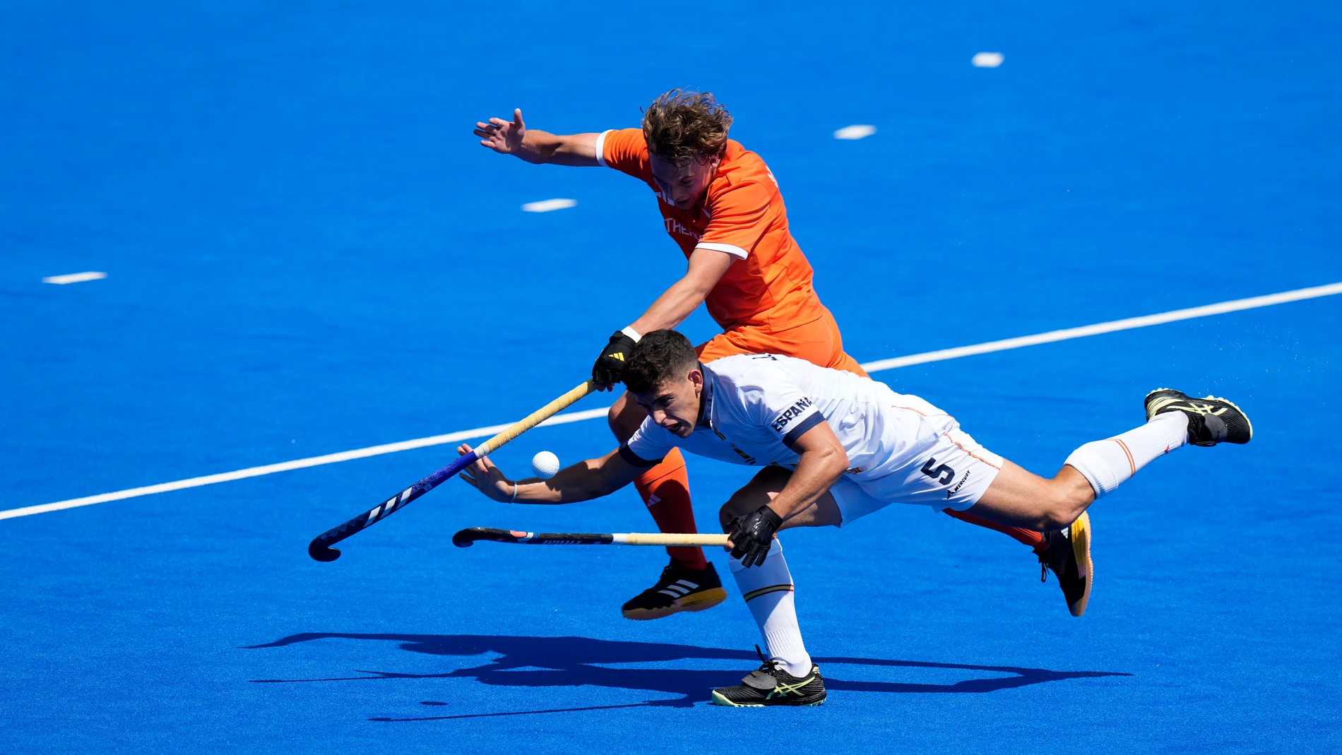 Spain's Jordi Bonastre loses his balance as he and Netherlands' Floris Middendorp compete for the ball during the men's semifinal field hockey match between Netherlands and Spain at the Yves-du-Manoir Stadium during the 2024 Summer Olympics, Tuesday, Aug. 6, 2024, in Colombes, France. (AP Photo/Aijaz Rahi)