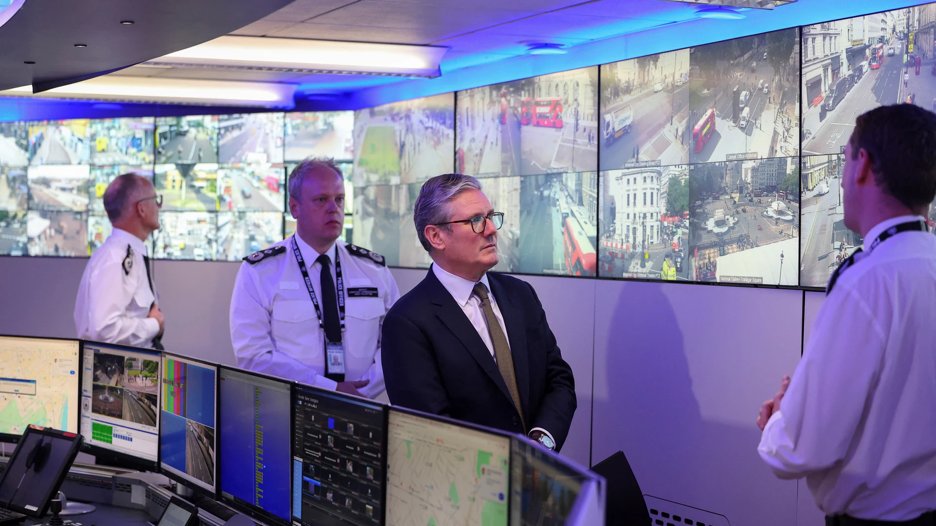 British Prime Minister Keir Starmer views CCTV screens with Metropolitan Police Commissioner Mark Rowley, Metropolitan Police Deputy Assistant Commissioner Andy Valentine and Commander Ben Russell as they visit the Engineering Suite in the Metropolitan Police Command and Control Special Operations Room at Lambeth Police Headquarters in London, Friday Aug. 9, 2024. (Toby Melville/Pool photo via AP)