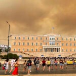 Humo de los incendios sobre la sede del Parlamento griego en Atenas 