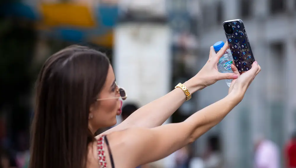 Joven interactuando con su teléfono móvil