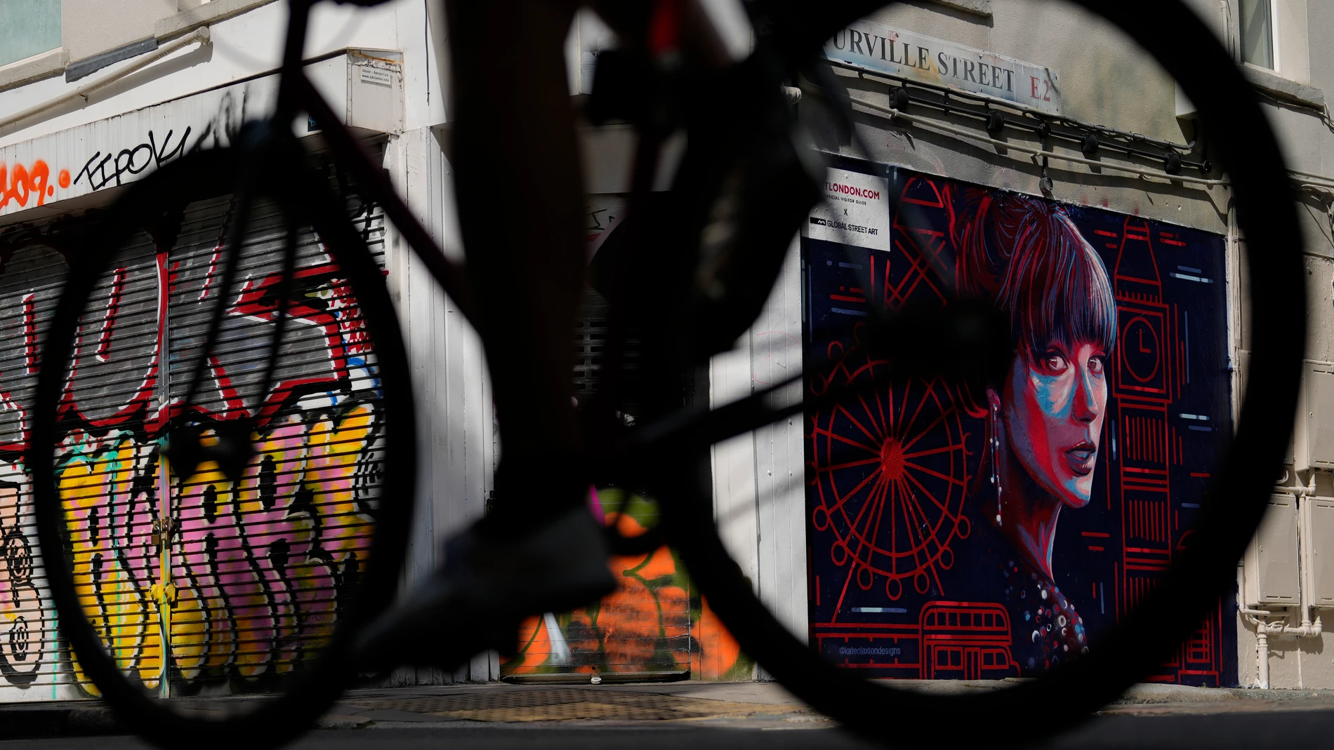 A cyclist passes by new mural portrait of Taylor Swift designed by Kate Clayton as it is unveiled in Shoreditch in east London, Tuesday, Aug. 13, 2024. (AP Photo/Alastair Grant)