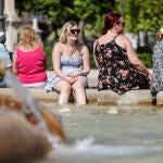 Una mujer se refresca en la fuente de la plaza de la Mare de Deu de Valencia