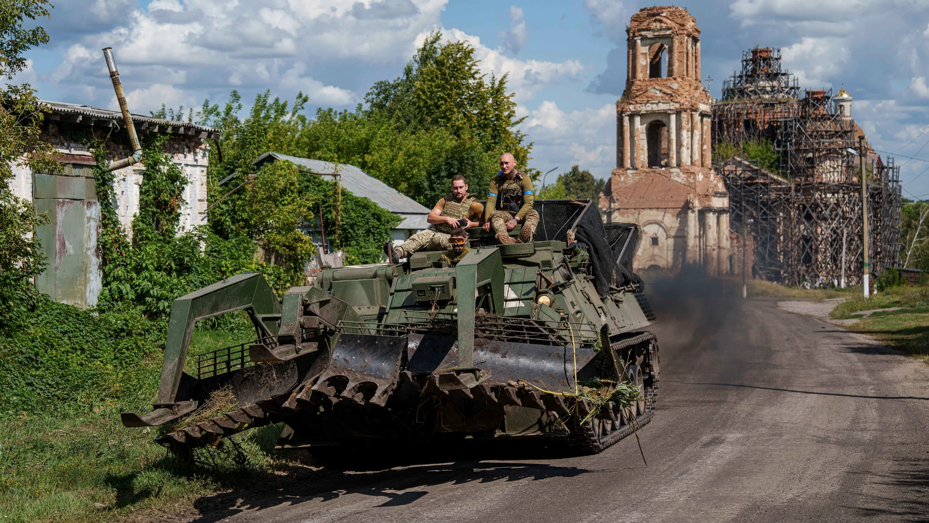 Ukrainian servicemen ride atop on armoured vehicle at the Russian-Ukrainian border in Sumy region, Ukraine, Wednesday, Aug. 14, 2024. (AP Photo/Evgeniy Maloletka)