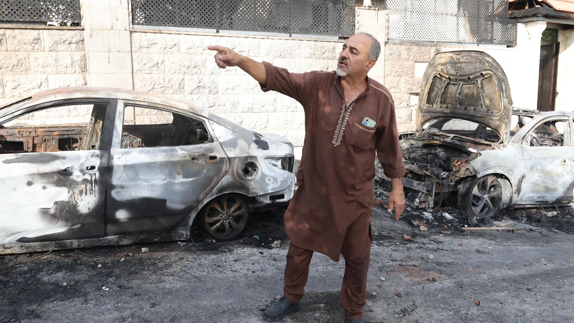 Jeit Village (-), 16/08/2024.- A Palestinian looks at burned cars after Israeli settlers set on fire the village of Jeit, near the West Bank city of Qalqilya, 16 August 2024. Israeli settlers attacked the village of Jeit on the evening of August 15, setting it on fire, in which one Palestinian was killed and five others were wounded, Palestinian Health Ministry said. The Israeli PM Office issued a statement condemning the attack and vowed to apprehend and prosecute those responsible. The UN O...