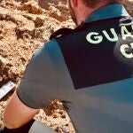 Un agente de la Guardia Civil junto a la granada de mortero.