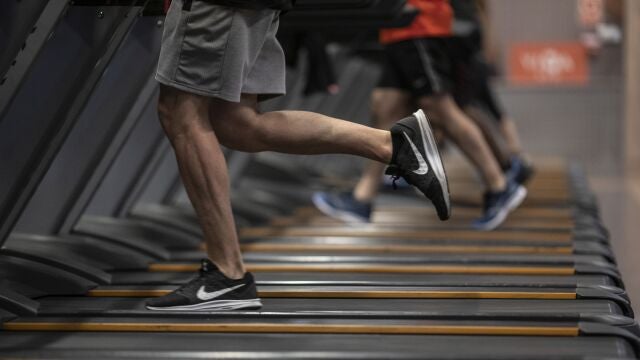 Gente corriendo en la cinta de un gimnasio.