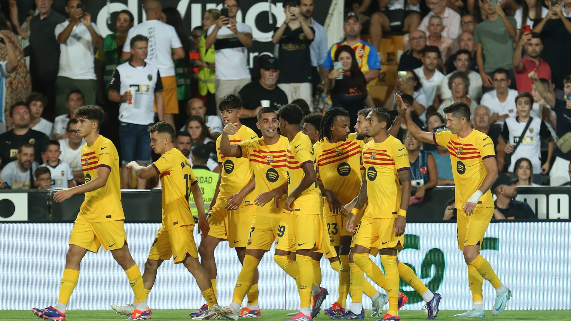 Barcelona's Robert Lewandowski, right, celebrates with teammates after scoring his side's second goal during the Spanish La Liga soccer match between Valencia and FC Barcelona at the Mestalla stadium in Valencia, Spain, Saturday, Aug. 17, 2024. (AP Photo/Alberto Saiz)