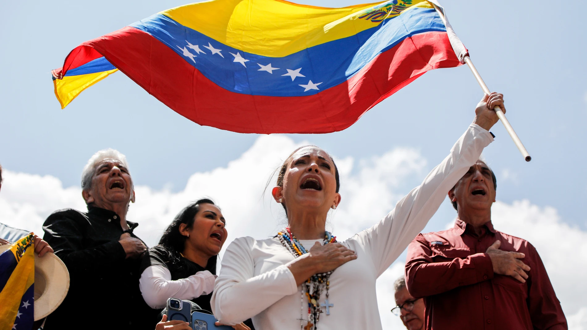 Opposition leader Maria Corina Machado waves a Venezuelan national flag during a rally to protest official results that declared President Nicolas Maduro the winner of the July presidential election, in Caracas, Venezuela, Saturday, Aug. 17, 2024. (AP Photo/Ariana Cubillos)