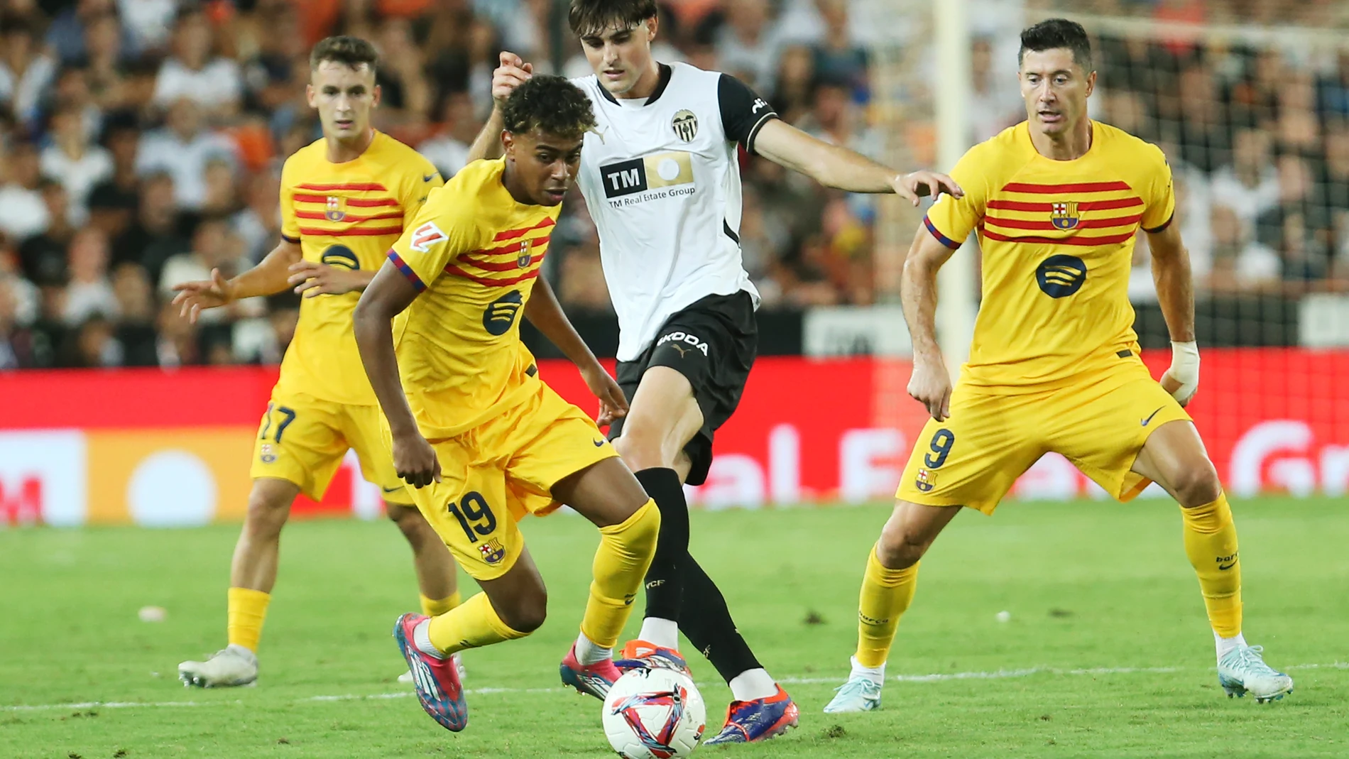 Barcelona's Lamine Yamal, centre left, and Valencia's Javi Guerra challenge for the ball during the Spanish La Liga soccer match between Valencia and FC Barcelona at the Mestalla stadium in Valencia, Spain, Saturday, Aug. 17, 2024. (AP Photo/Alberto Saiz)
