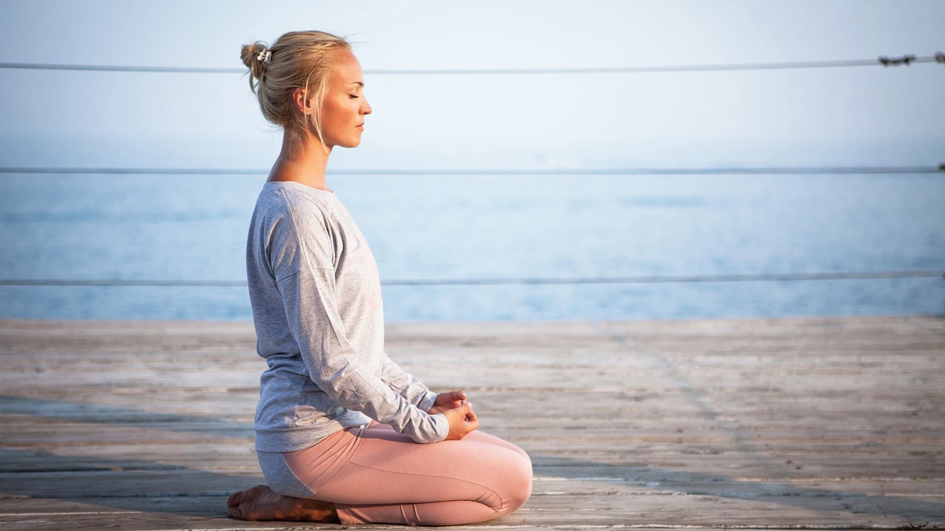 Mujer meditando en la costa
