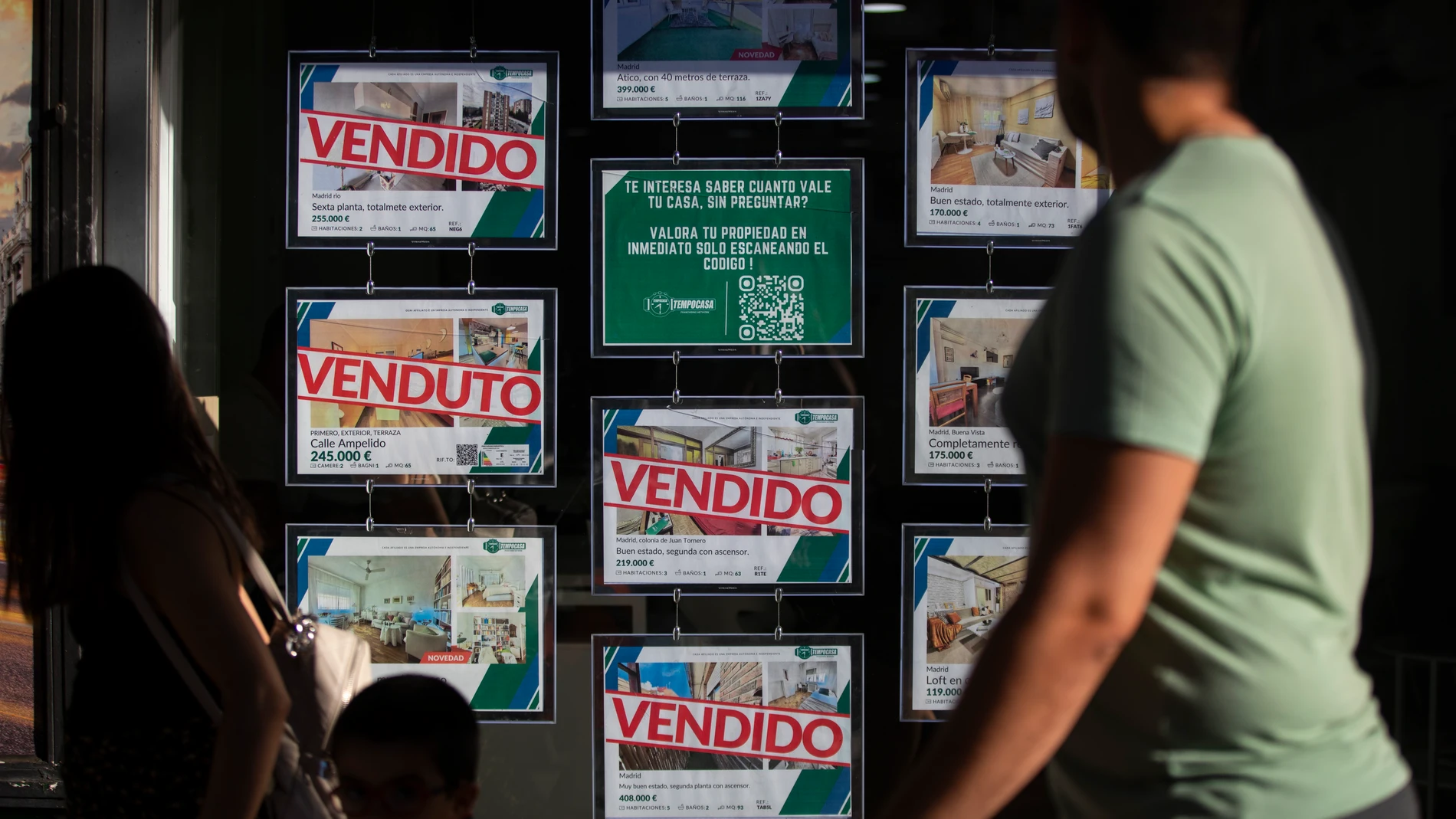 Imagen de una inmobiliaria con anuncios de pisos y casas con algunos carteles de vendido. © Jesús G. Feria.