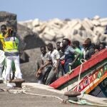 Migrants disembark from a wooden boat at the port in La Restinga on the Canary island of El Hierro, Spain, Sunday, Aug. 18, 2024. Emergency services on Spain's Canary Islands say 175 migrants have arrived in a boat on the Canary Island of El Hierro on Sunday, after a seven-day sailing from the coast of Senegal. (AP Photo/Maria Ximena)