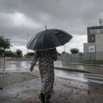 Una mujer camina bajo la lluvia