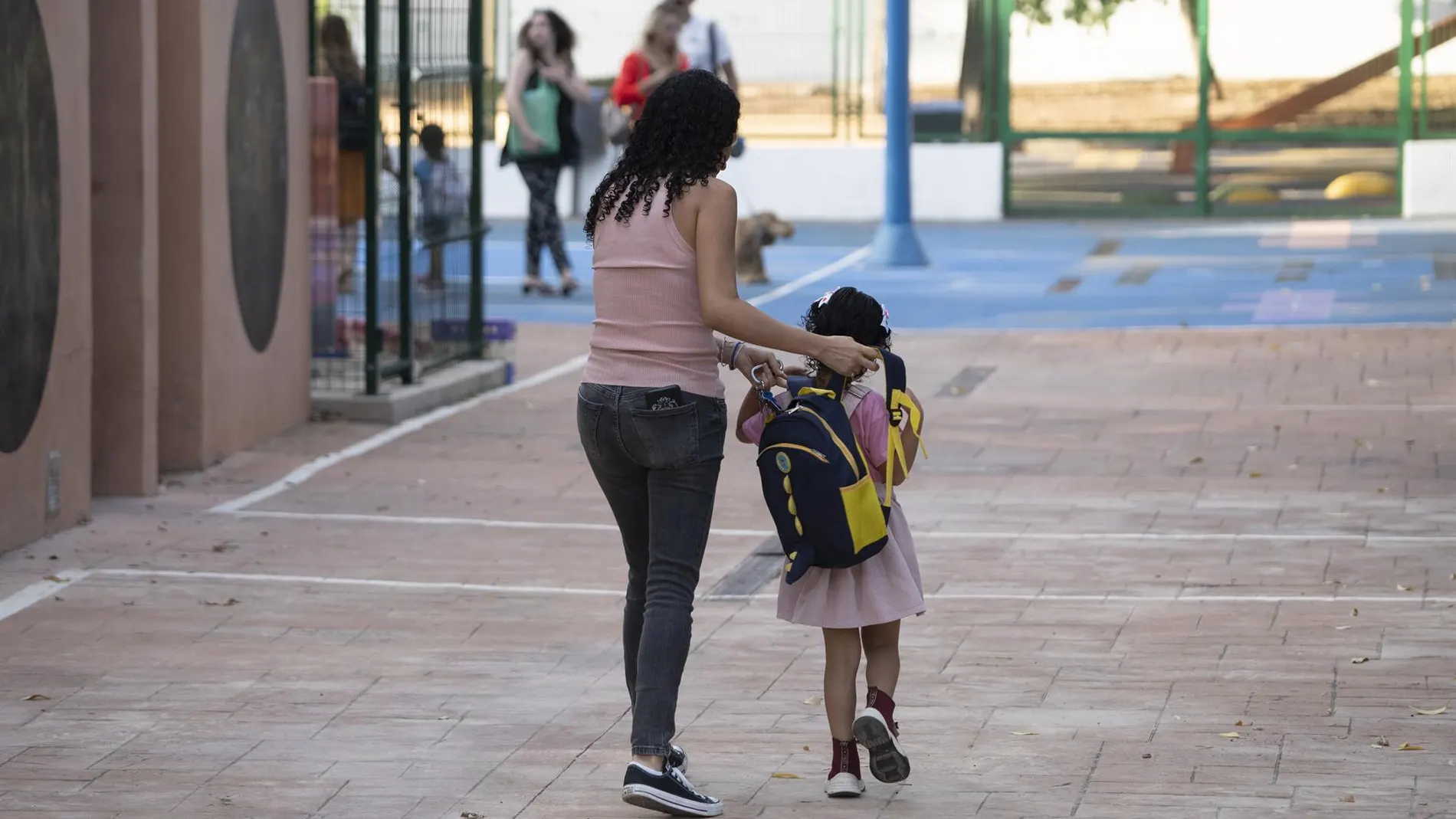 Imagen de archivo de una madre acompañando a su hija a clase.