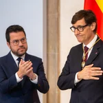 El expresident de la Generalitat, Pere Aragonès (i) y el nuevo president de la Generalitat de Cataluña, Salvador Illa (d), durante la toma de posesión de Salvador Illa como president de la Generalitat, en el Palau de la Generalitat