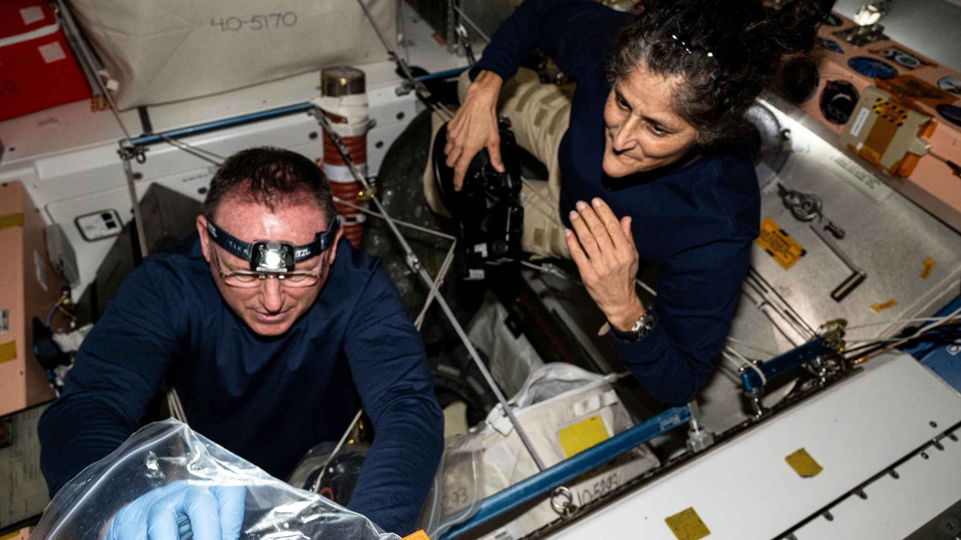 In this photo provided by NASA, astronauts Butch Wilmore, left, and Suni Williams inspect safety hardware aboard the International Space Station on Aug. 9, 2024. (NASA via AP)