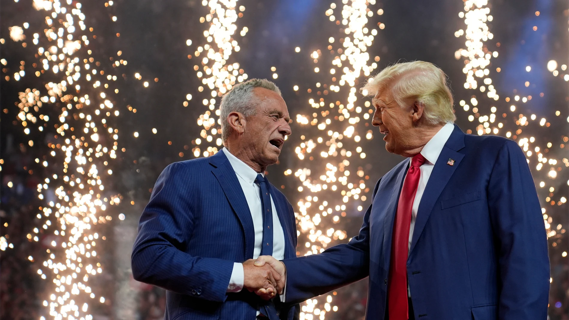 Republican presidential nominee former President Donald Trump shakes hands with Independent presidential candidate Robert F. Kennedy Jr. at a campaign rally at the Desert Diamond Arena, Friday, Aug. 23, 2024, in Glendale, Ariz. (AP Photo/Evan Vucci)