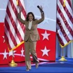 Democratic presidential nominee Vice President Kamala Harris raises her arms as she walks on stage during the Democratic National Convention 