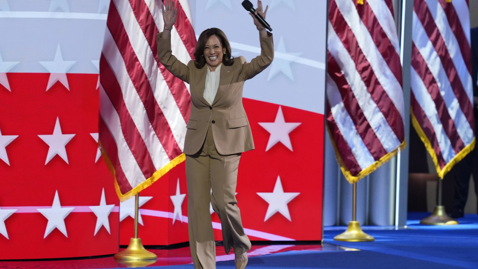 Democratic presidential nominee Vice President Kamala Harris raises her arms as she walks on stage during the Democratic National Convention