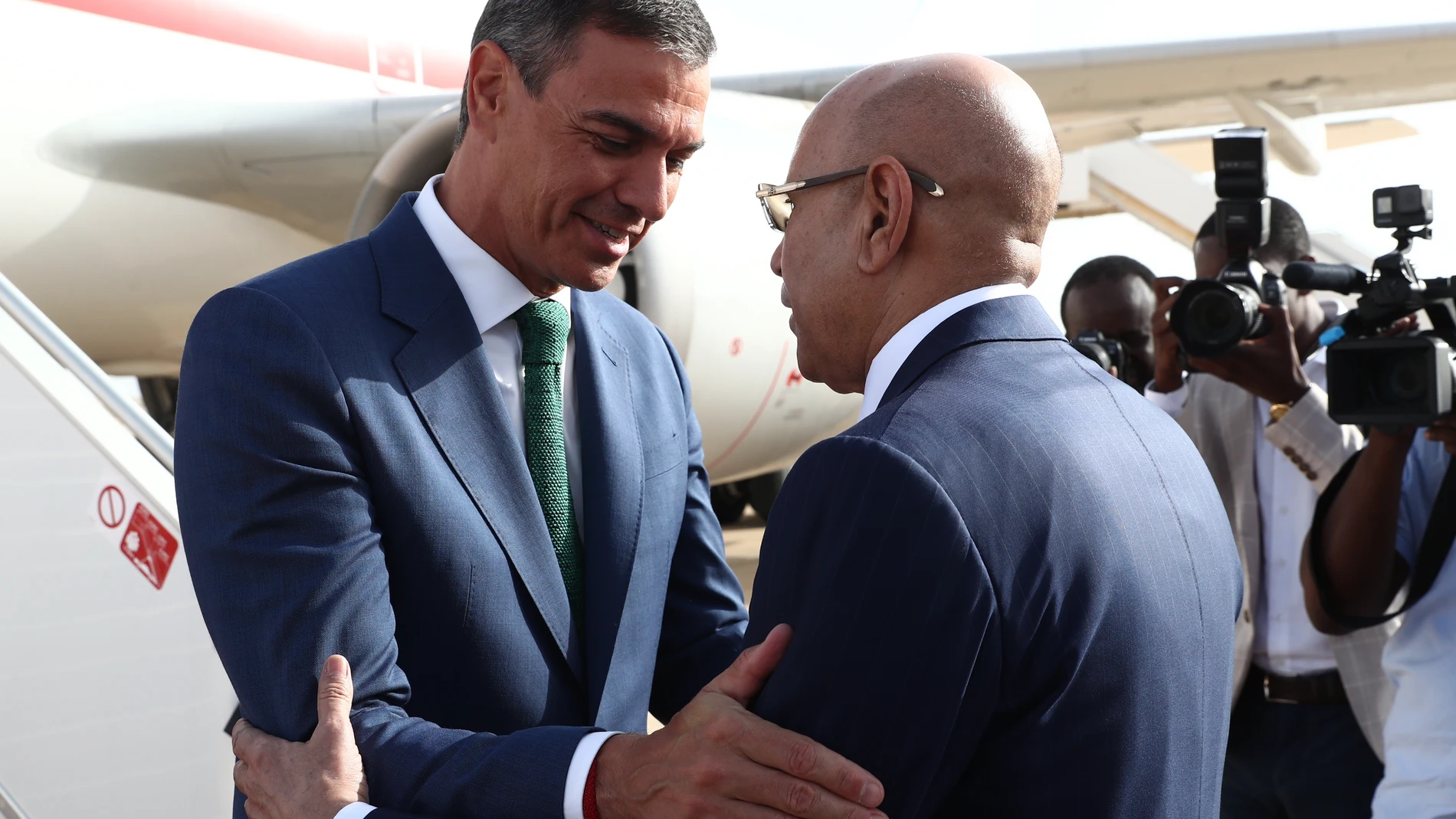NUAKCHOT (MAURITANIA), 27/08/2024.- El presidente del Gobierno, Pedro Sánchez, saluda al presidente de la República Islámica de Mauritania, Mohamed Cheikh El Ghazouani, a su llegada este martes al aeropuerto de Nuakchot, en la primera etapa de su gira africana, que incluye también Gambia y Senegal, para reforzar la cooperación migratoria en un momento de especial presión, con un goteo de cayucos procedentes de estos países que llegan a las costas canarias. EFE/Moncloa/Fernando Calvo -SOLO USO...