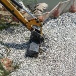 Una grúa recoge los peces en una red protectora en Volos 