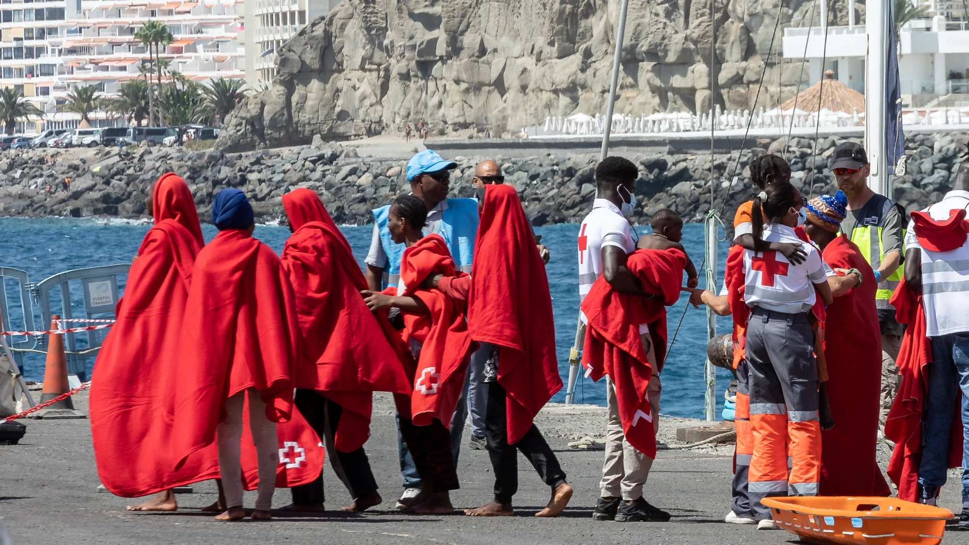 Varios migrantes son atendidos por los Servicios de Emergencias en el Muelle de Arguineguín, a 28 de agosto de 2024, en Gran Canaria, Canarias (España). Salvamento Marítimo ha rescatado un cayuco a la deriva con unos 120 migrantes subsaharianos, entre los que hay una mujer en estado grave, cuando navegaban a unas 320 millas náuticas (unos 590 kilómetros) al sur de la isla de Gran Canaria y que habrían salido hace dos días de Nouachotk (Mauritania). 28 AGOSTO 2024;INMIGRACIÓN;MIGRANTES;CRISIS...