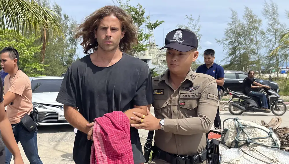 A Thai police officer escorts Spanish Daniel Sancho Bronchalo on suspicion of murdering and dismembering a Colombian surgeon from Koh Phagnan island to Koh Samui Island court, southern Thailand, Monday, Aug. 7, 2023.