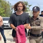 A Thai police officer escorts Spanish Daniel Sancho Bronchalo on suspicion of murdering and dismembering a Colombian surgeon from Koh Phagnan island to Koh Samui Island court, southern Thailand, Monday, Aug. 7, 2023. 