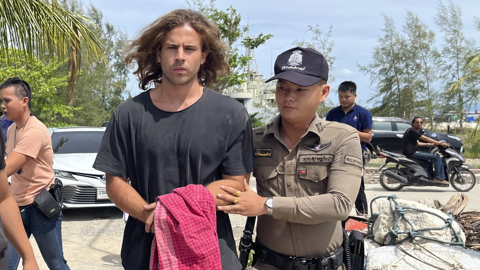 A Thai police officer escorts Spanish Daniel Sancho Bronchalo on suspicion of murdering and dismembering a Colombian surgeon from Koh Phagnan island to Koh Samui Island court, southern Thailand, Monday, Aug. 7, 2023.