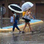 Imagen de dos mujeres bajo la lluvia y el granizo
