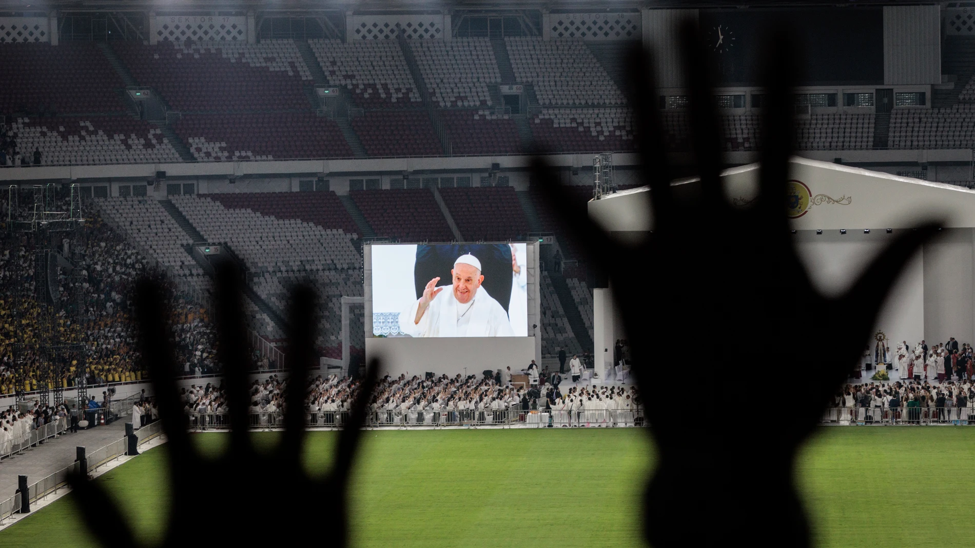 Catholic faithful attend a holy mass led by Pope Francis, shown on the screen, at the Gelora Bung Karno Stadium, in Jakarta, Thursday, Sept. 5, 2024. (Yasuyoshi Chiba/Pool Photo via AP)