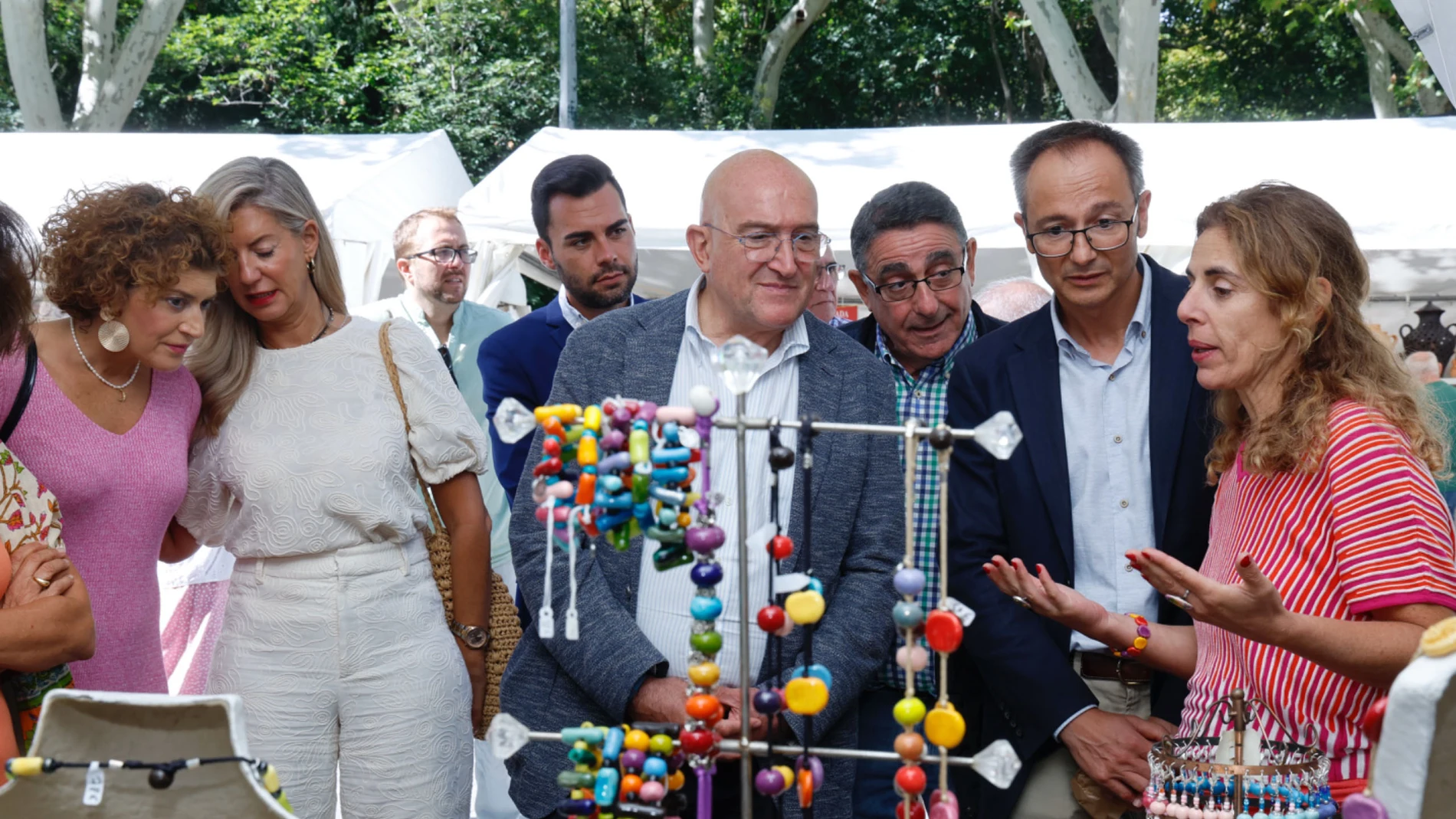 El alcalde de Valladolid, Jesús Julio Carnero, visita uno de los 54 expositores de artesanos presentes en la feria de cerámica y alfarería junto a Juan Carlos Jimeno, presidente de la Asociación de Ceramistas Vallisoletanos-ACEVA,
