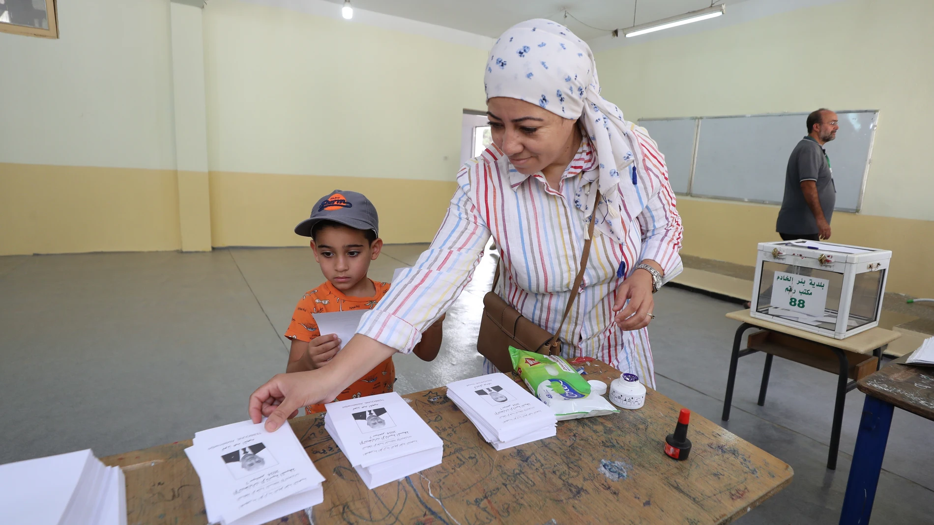 Algiers (Algeria), 07/09/2024.- An Algerian woman picks up ballot papers before casting her vote at a polling station during the Presidential election in Algiers, Algeria, 07 September 2024. According to the National Independent Authority for Elections (ANIE), more than 24 million Algerians are called to the polls to elect a new president of the republic for a five-year term. Three candidates are in the running for this election; the national secretary of the Socialist Forces Front (FFS), You...