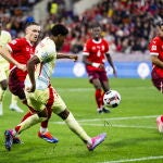 Lamine Yamal centrando el balón mientras lo marca Aebischer 